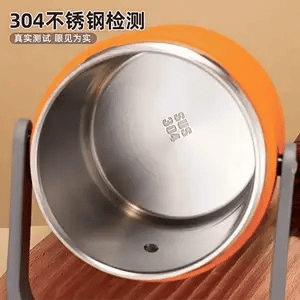 Stainless steel pot with orange lid on a wooden surface