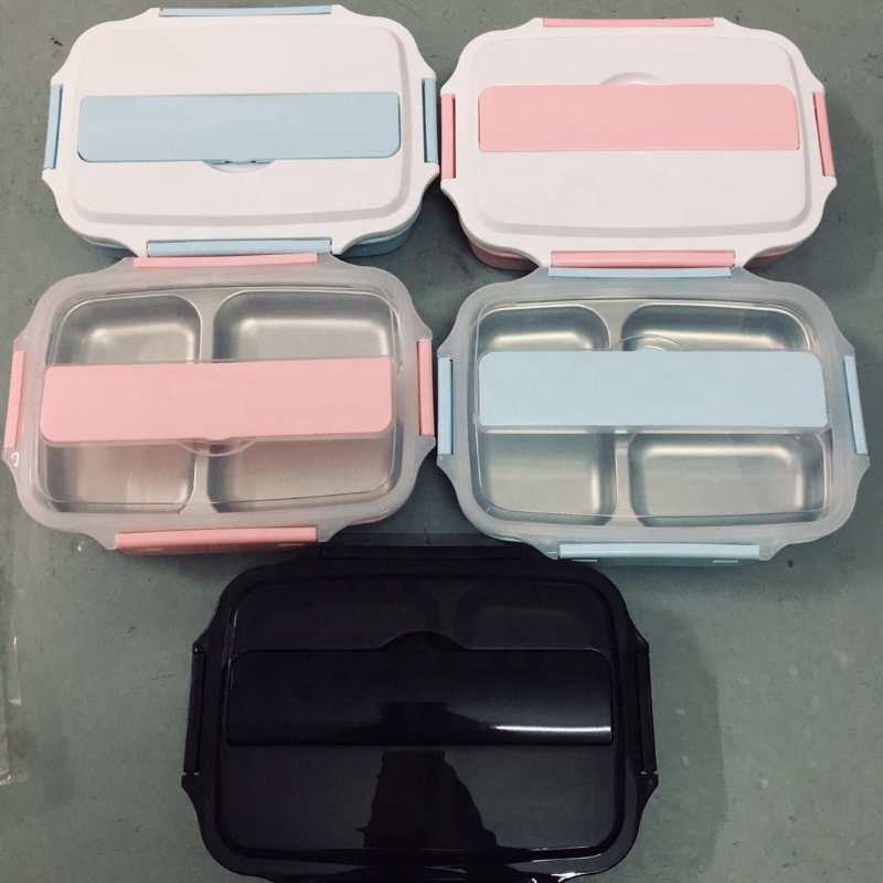 Set of four bento boxes with pink and black lids on a gray surface