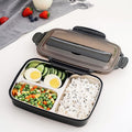 Bento box with compartments of rice, vegetables, and eggs on a white surface.